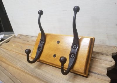 Metal rack with two handmade hooks to hold coats or other items.